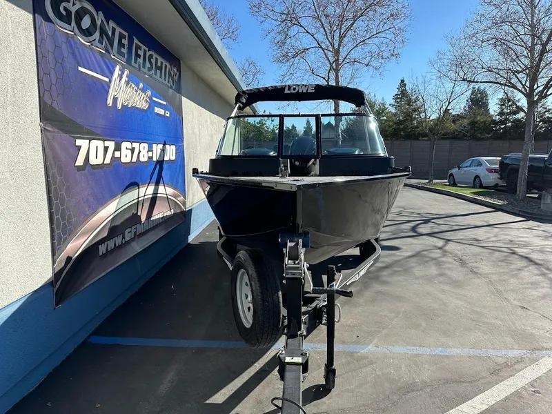 Slide: The Image of 2019 Lowe FM 165 Pro WT boat on trailer, parked near fishing store. - 3