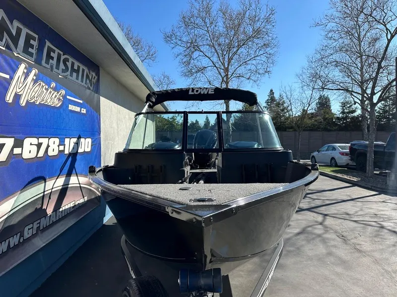Slide: The Image of 2019 Lowe FM 165 Pro WT boat displayed outdoors at a marine dealership. - 5