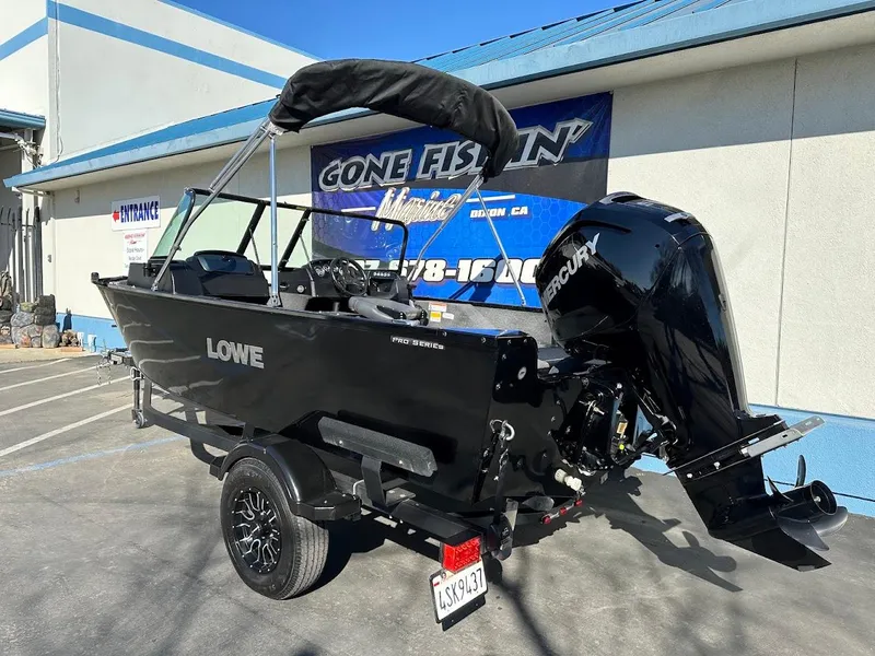 Slide: The Image of 2019 Lowe FM 165 Pro WT boat with Mercury engine, parked outside a building. - 9