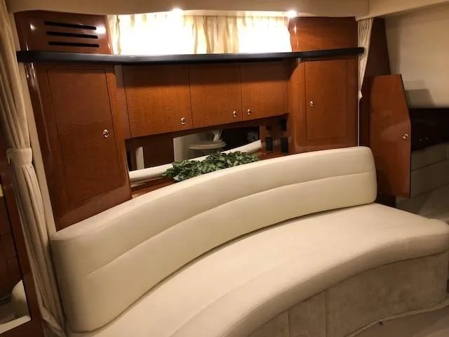 Slide: The Image of Interior of 2003 Sea Ray 340 Sundancer with curved seating and wooden cabinetry. - 12