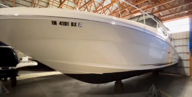 Slide: The Image of 2003 Sea Ray 340 Sundancer boat stored indoors, showcasing sleek design and white hull. - 16