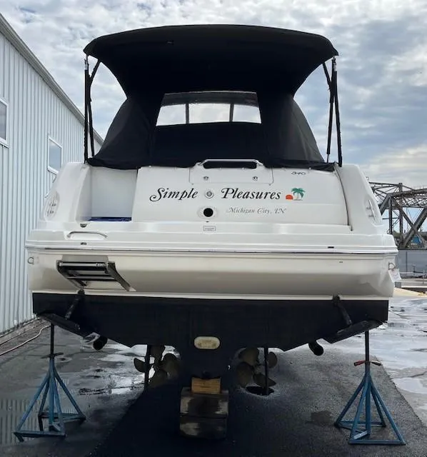 Slide: The Image of 2003 Sea Ray 340 Sundancer boat on stands, covered, with "Simple Pleasures" text on the back. - 19