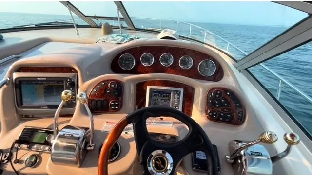 Slide: The Image of Cockpit view of 2003 Sea Ray 340 Sundancer, featuring steering wheel and control panel. - 3