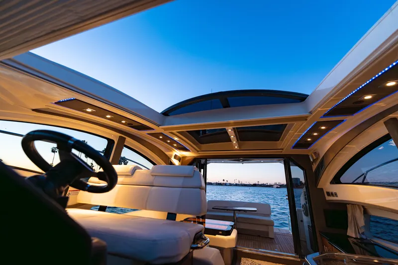 Slide: The Image of Interior view of 2009 Marquis 420 Sport Coupe yacht at sunset, featuring luxurious seating and panoramic windows. - 17