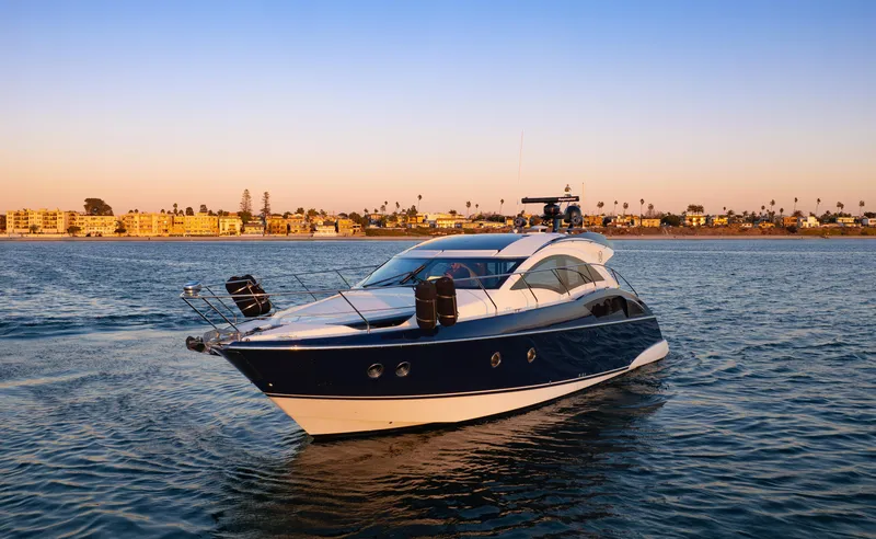 Slide: The Image of 2009 Marquis 420 Sport Coupe yacht cruising on calm waters at sunset. - 2