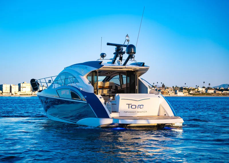 Slide: The Image of 2009 Marquis 420 Sport Coupe yacht on calm water, sunny day, coastal background. - 5