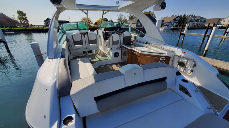 Slide: The Image of 2021 Four Winns H350 boat with spacious seating, docked in a serene marina setting. - 21