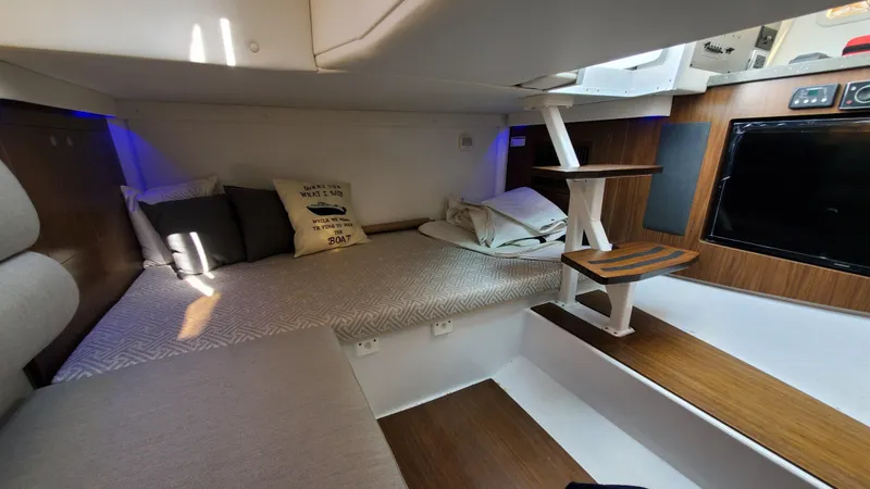 Slide: The Image of 2021 Four Winns H350 cabin interior with cozy bedding and modern wooden accents. - 37