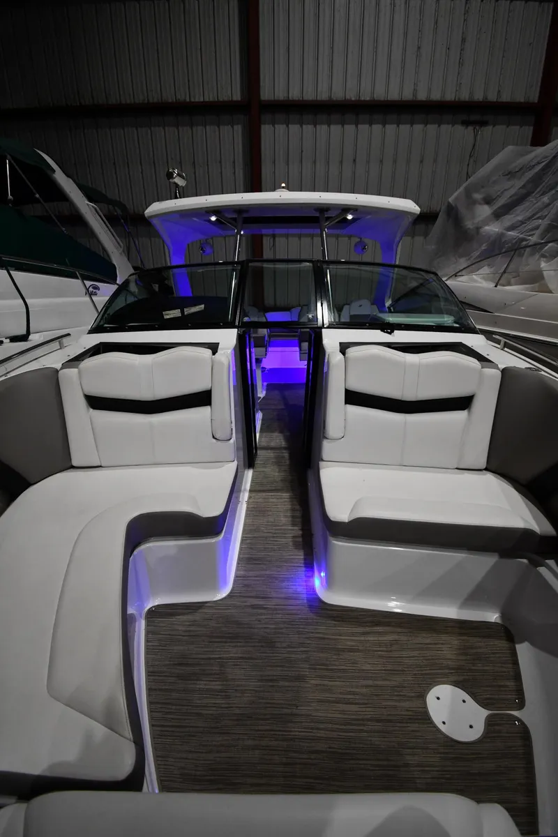 Slide: The Image of 2021 Four Winns H350 boat interior with ambient blue lighting and sleek seating. - 47