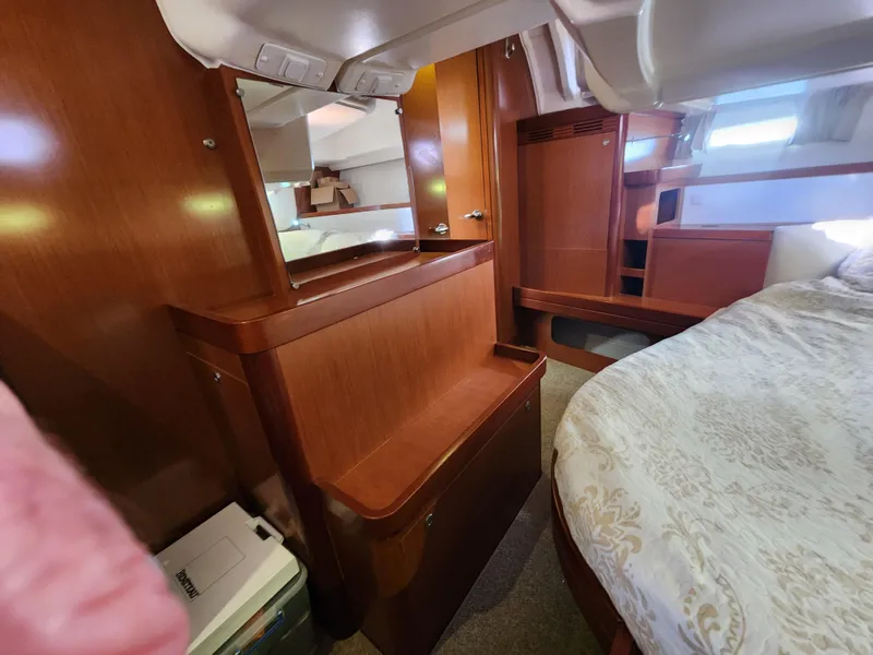 Slide: The Image of Interior of 2012 Beneteau Oceanis 50 yacht, featuring wood finish and cozy sleeping area. - 25