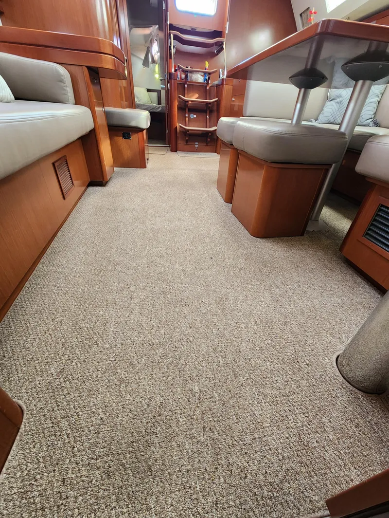 Slide: The Image of Interior of 2012 Beneteau Oceanis 50 yacht with plush carpet and wooden furnishings. - 27