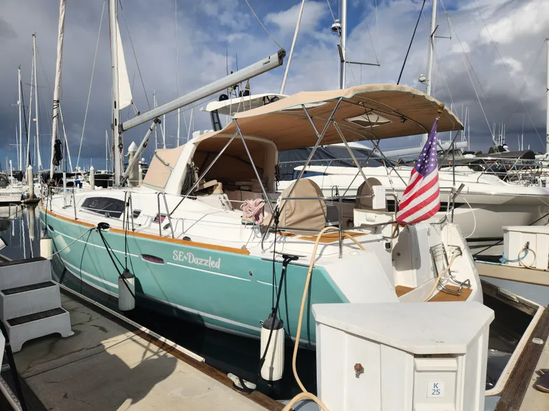 Slide: The Image of Beneteau Oceanis 50 sailboat, 2012 model, docked with American flag, beige canopy, and turquoise hull. - 4