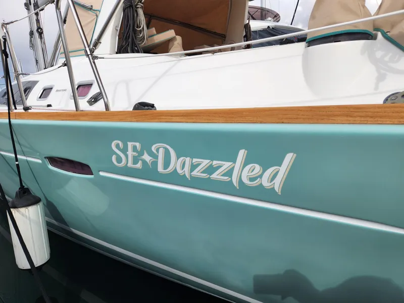 Slide: The Image of 2012 Beneteau Oceanis 50 sailboat with "SE Dazzled" name on turquoise hull. - 5