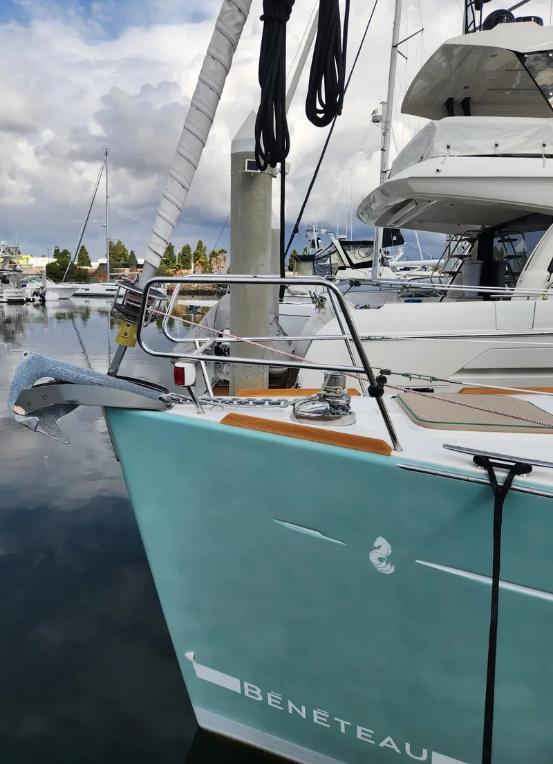 Slide: The Image of 2012 Beneteau Oceanis 50 sailboat docked in marina, turquoise hull, overcast sky. - 7
