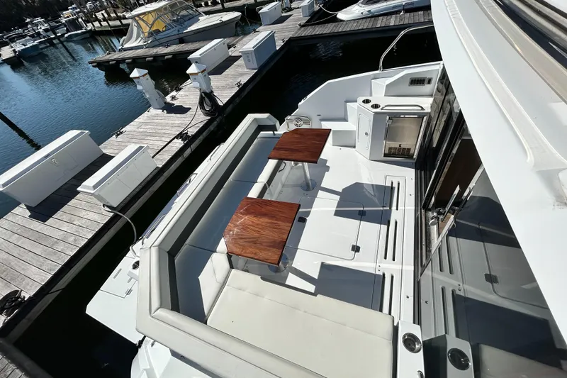 Slide: The Image of 2022 Cruisers Yachts 42 Cantius deck with seating and tables at marina. - 15