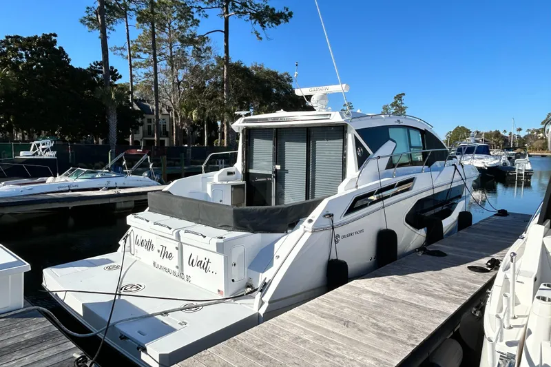 Slide: The Image of 2022 Cruisers Yachts 42 Cantius docked at a marina under clear blue skies. - 2