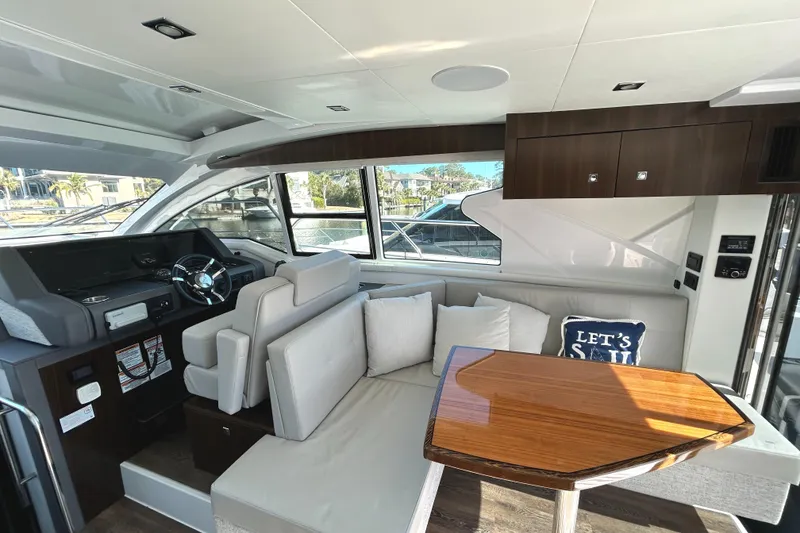 Slide: The Image of Interior of 2022 Cruisers Yachts 42 Cantius with modern seating and wooden table. - 25