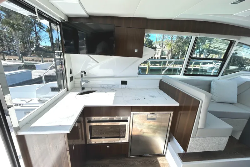 Slide: The Image of Modern interior of 2022 Cruisers Yachts 42 Cantius with kitchen and seating area. - 26