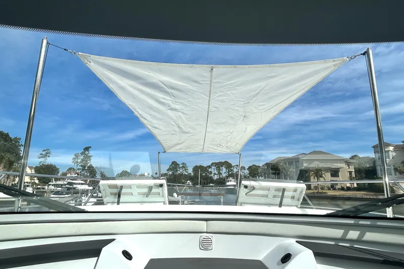 Slide: The Image of 2022 Cruisers Yachts 42 Cantius with sunshade, docked in a scenic marina. - 34