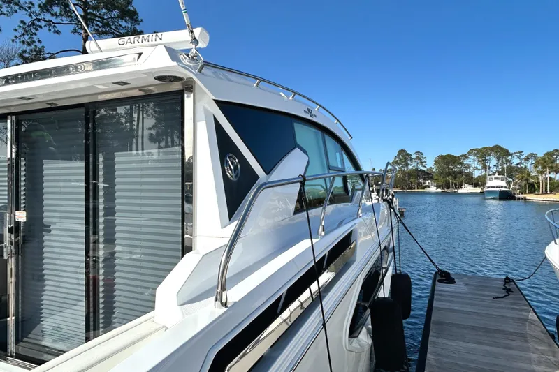 Slide: The Image of 2022 Cruisers Yachts 42 Cantius docked by a serene waterfront. - 5
