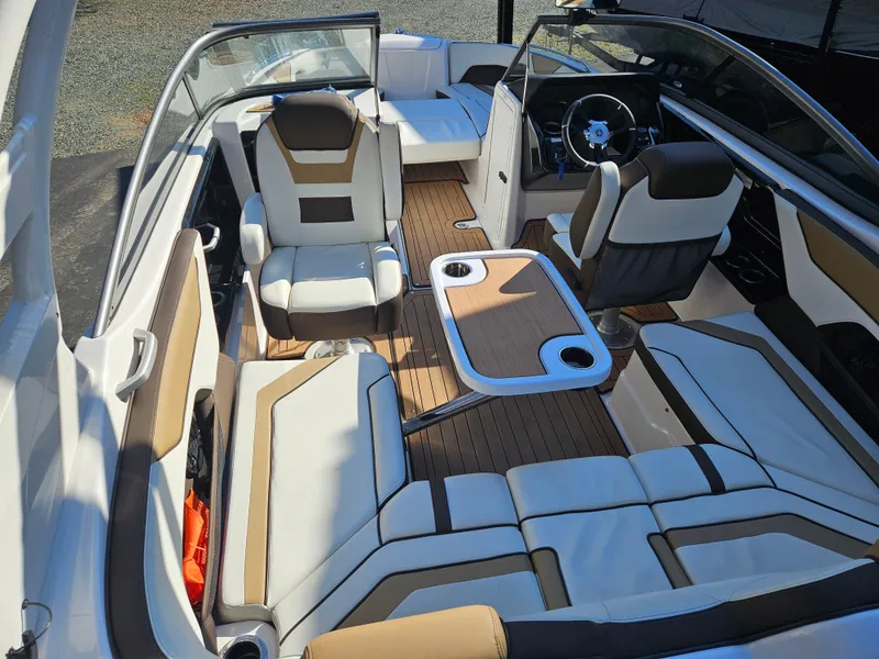 Slide: The Image of 2022 Yamaha Boats 212S interior with modern seating and table setup. - 16