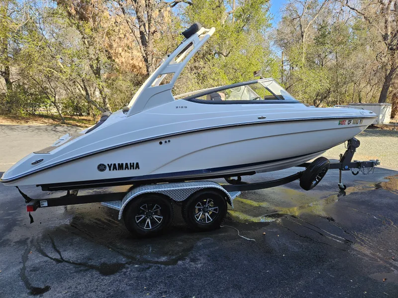 Slide: The Image of 2022 Yamaha Boats 212S on trailer, parked outdoors, side view. - 18