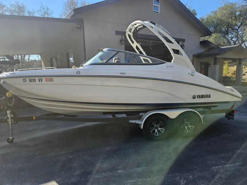 Slide: The Image of 2022 Yamaha Boats 212S on trailer, parked outside a house. - 6