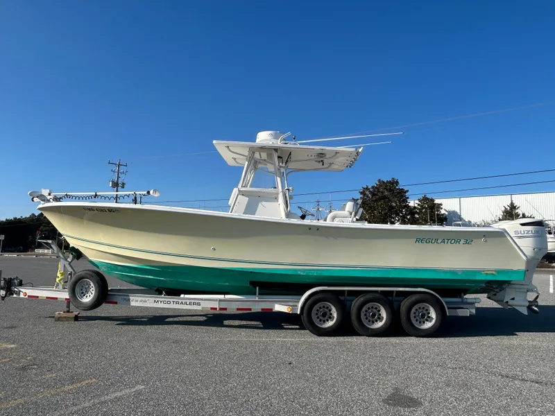 Slide: The Image of 2000 Regulator 32 Classic boat on trailer, parked outdoors under clear blue sky. - 1