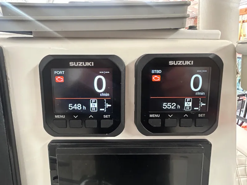Slide: The Image of Suzuki engine displays on a 2000 Regulator 32 Classic boat, showing hours and RPM. - 15