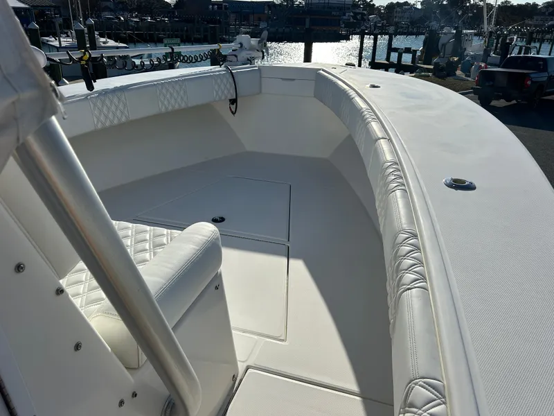 Slide: The Image of 2000 Regulator 32 Classic boat interior with white seating and deck, docked at marina. - 20