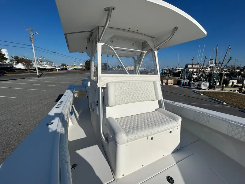 Slide: The Image of 2000 Regulator 32 Classic boat with T-top and cushioned seating, docked in a marina. - 26