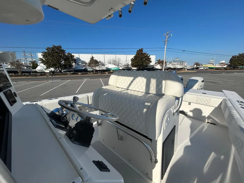 Slide: The Image of Regulator 32 Classic 2000 boat interior with steering wheel and seating, parked outdoors. - 29