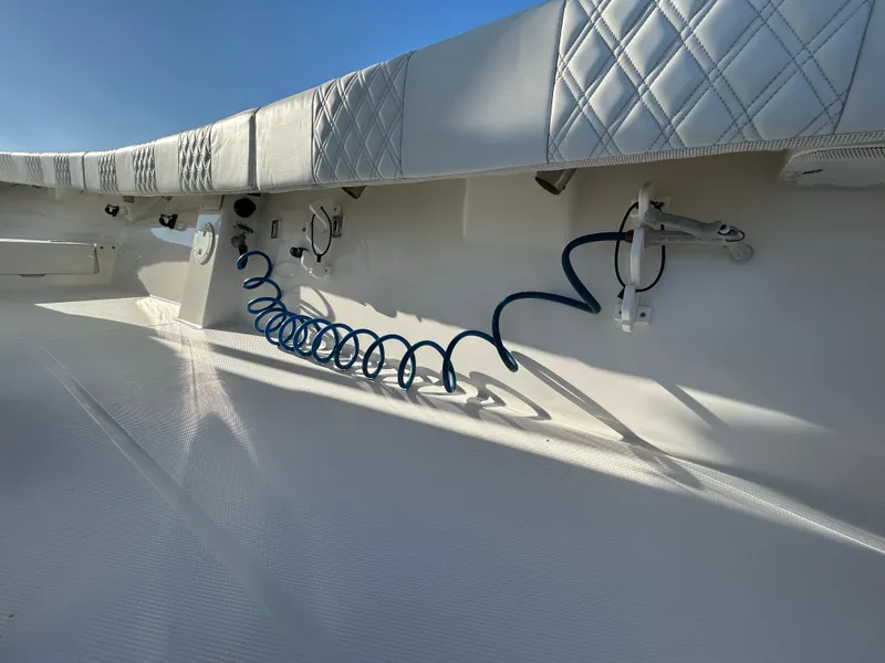 Slide: The Image of Interior view of a 2000 Regulator 32 Classic boat, featuring coiled hose and cushioned seating. - 30