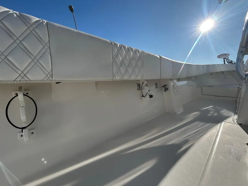 Slide: The Image of 2000 Regulator 32 Classic boat interior with quilted upholstery under bright sunlight. - 31