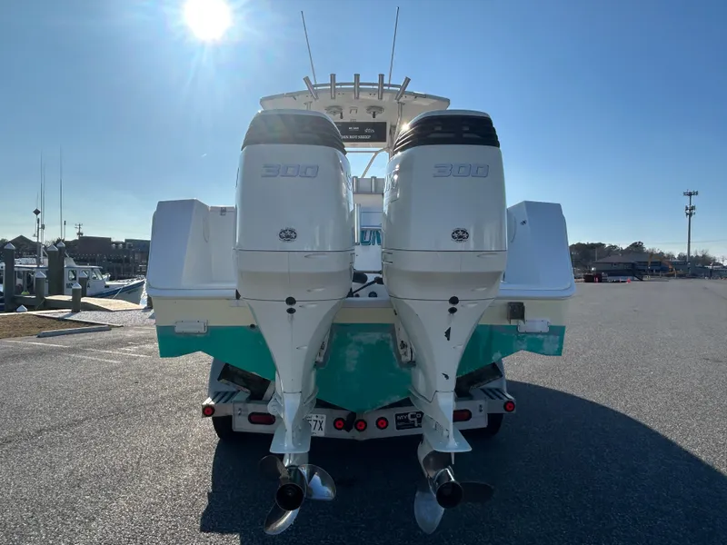 Slide: The Image of 2000 Regulator 32 Classic boat with twin outboard engines, parked on a trailer. - 6