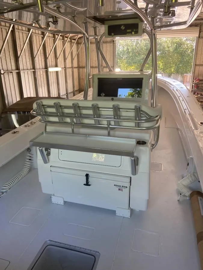 Slide: The Image of 2024 Contender 35 ST boat interior with helm station and storage, docked in a shed. - 3