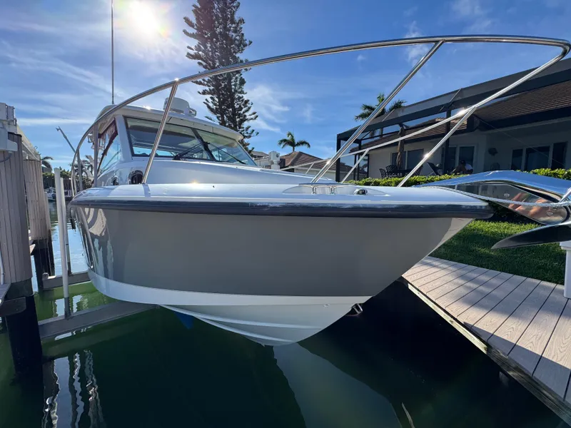 Slide: The Image of 2017 Boston Whaler 315 Conquest boat docked in sunny marina setting. - 2