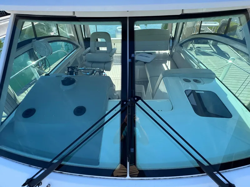 Slide: The Image of 2017 Boston Whaler 315 Conquest interior view through windshield, showcasing seating and dashboard. - 30