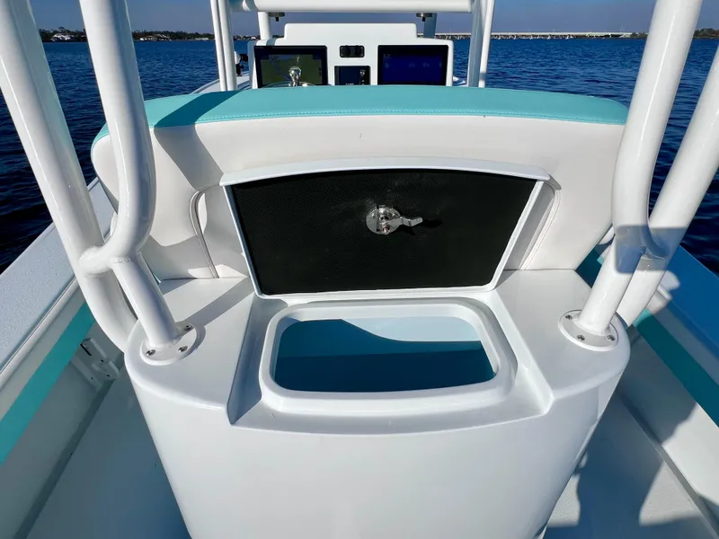 Slide: The Image of 2022 Yellowfin 26 Hybrid boat interior with storage compartment, on calm blue water. - 21