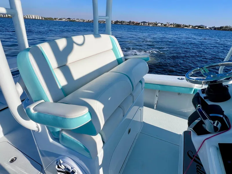 Slide: The Image of 2022 Yellowfin 26 Hybrid boat interior with comfortable seating, overlooking calm blue waters. - 27