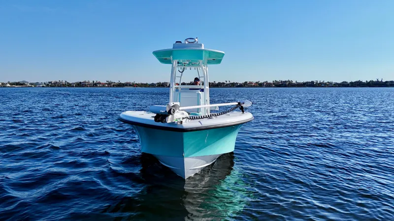Slide: The Image of 2022 Yellowfin 26 Hybrid boat on calm water, front view, clear blue sky. - 3