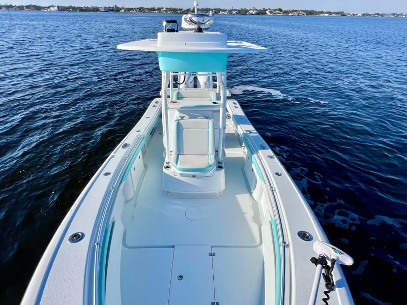 Slide: The Image of 2022 Yellowfin 26 Hybrid boat on water, featuring spacious deck and modern design. - 32