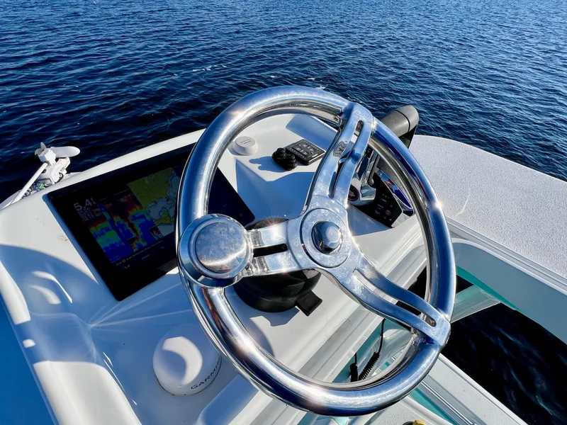 Slide: The Image of Steering wheel of 2022 Yellowfin 26 Hybrid boat on water, featuring navigation display. - 39