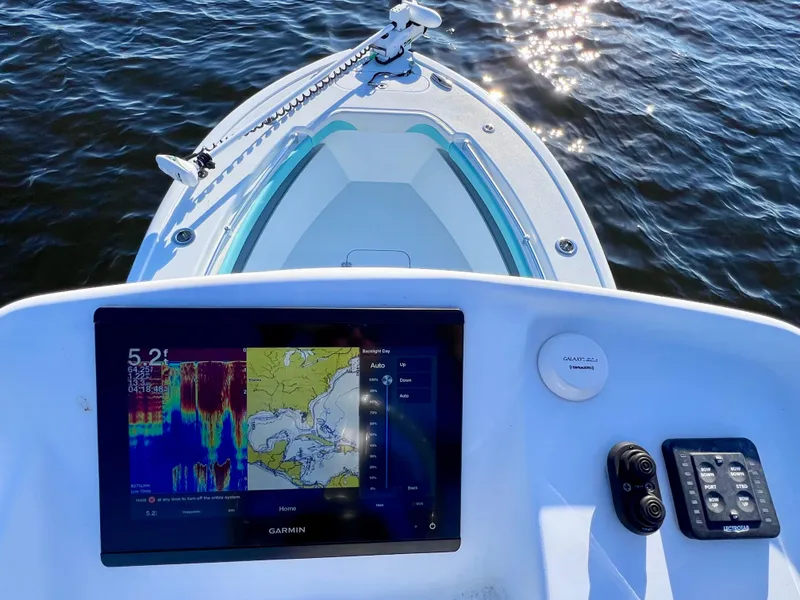 Slide: The Image of 2022 Yellowfin 26 Hybrid boat dashboard with Garmin display, on calm water. - 40