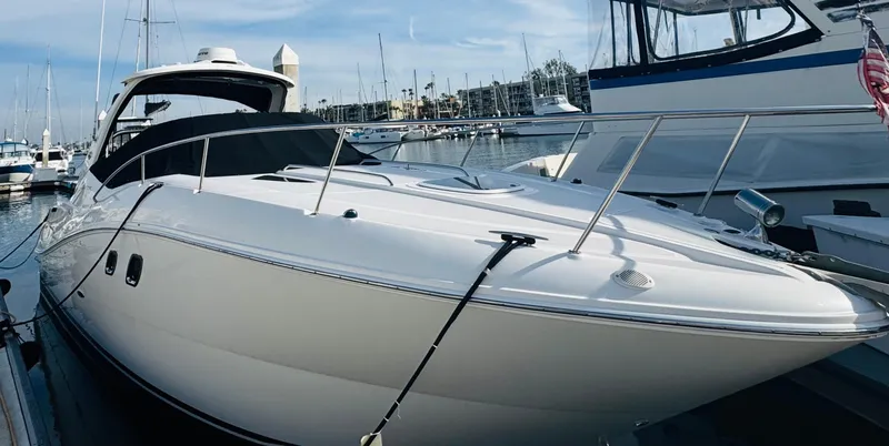 Slide: The Image of 2007 Sea Ray 310 Sundancer yacht docked at marina, sleek white design. - 0