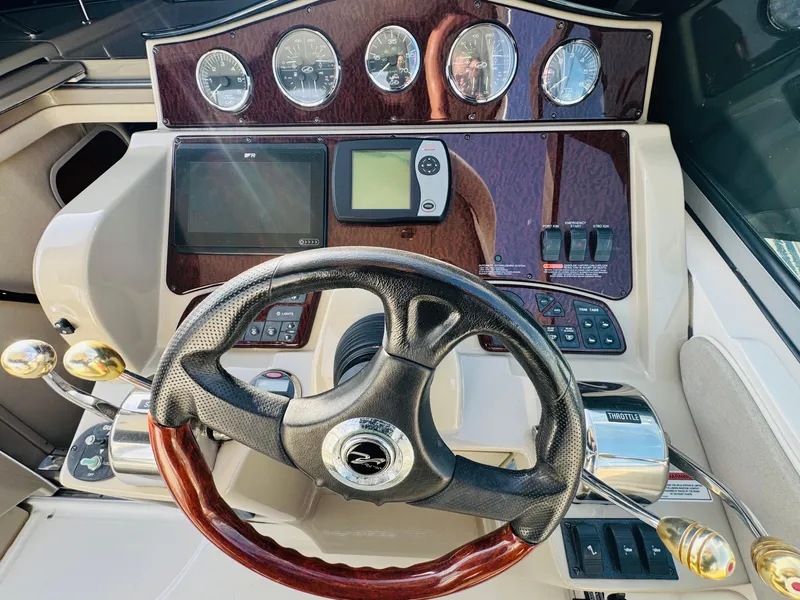 Slide: The Image of 2007 Sea Ray 310 Sundancer helm with gauges, steering wheel, and navigation controls. - 11