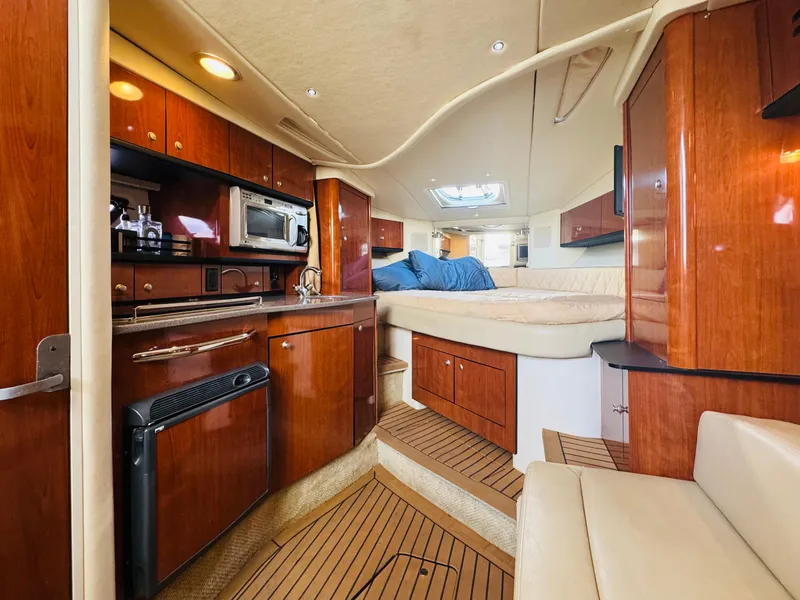 Slide: The Image of Interior of 2007 Sea Ray 310 Sundancer yacht with wood cabinetry and cozy sleeping area. - 12