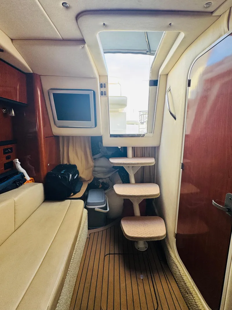 Slide: The Image of Interior of a 2007 Sea Ray 310 Sundancer boat, featuring seating and a compact cabin space. - 15