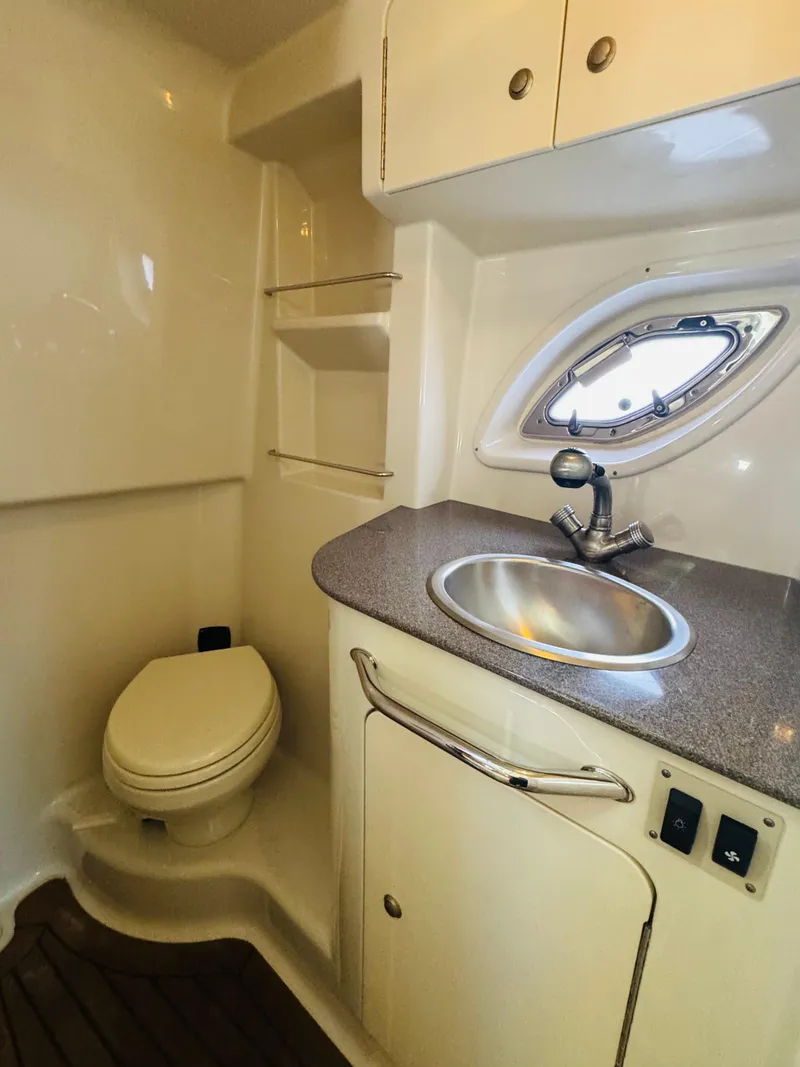 Slide: The Image of 2007 Sea Ray 310 Sundancer bathroom with sink, toilet, and porthole window. - 16