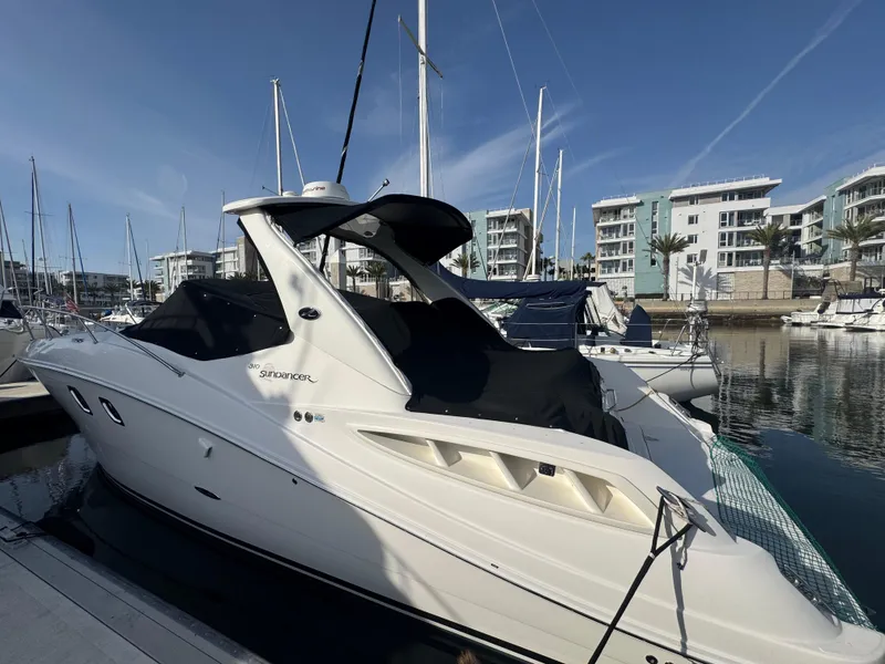 Slide: The Image of 2007 Sea Ray 310 Sundancer docked at marina with modern buildings in background. - 2